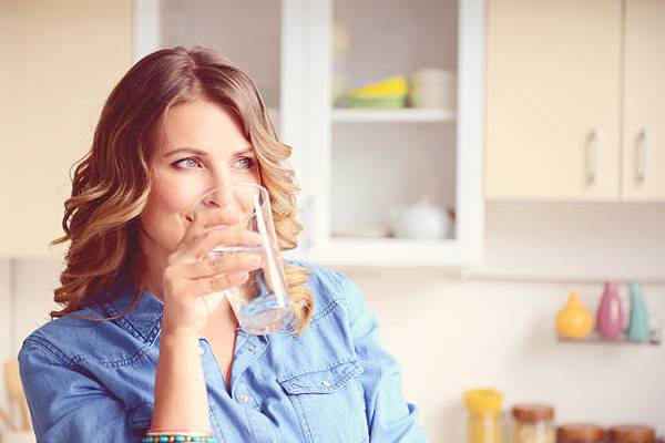 woman-drinking-water-kitchen