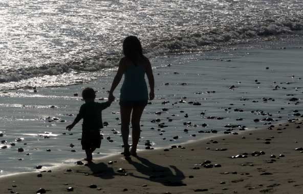 mom and son walking along the seashore